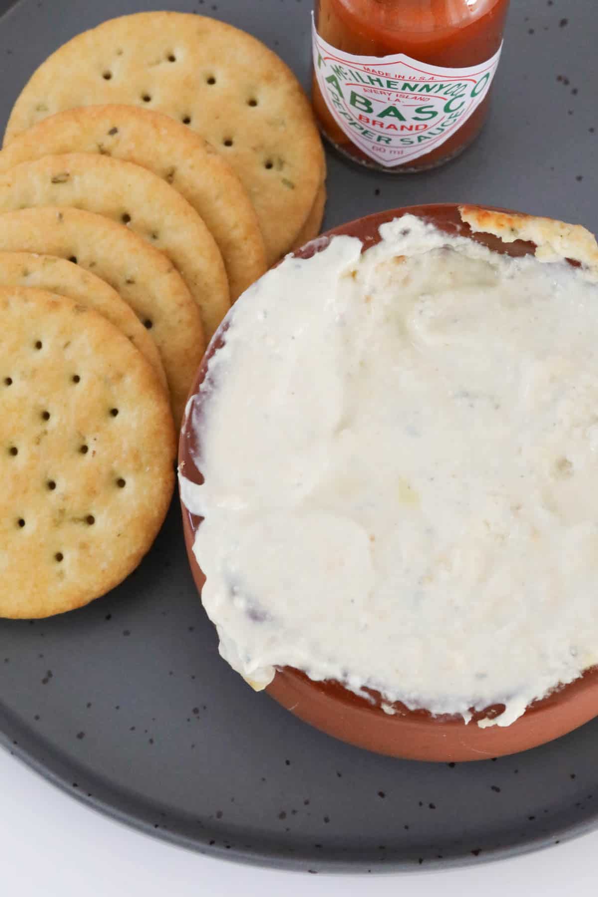 Overhead shot of warm blue cheese dip with crackers on the side.