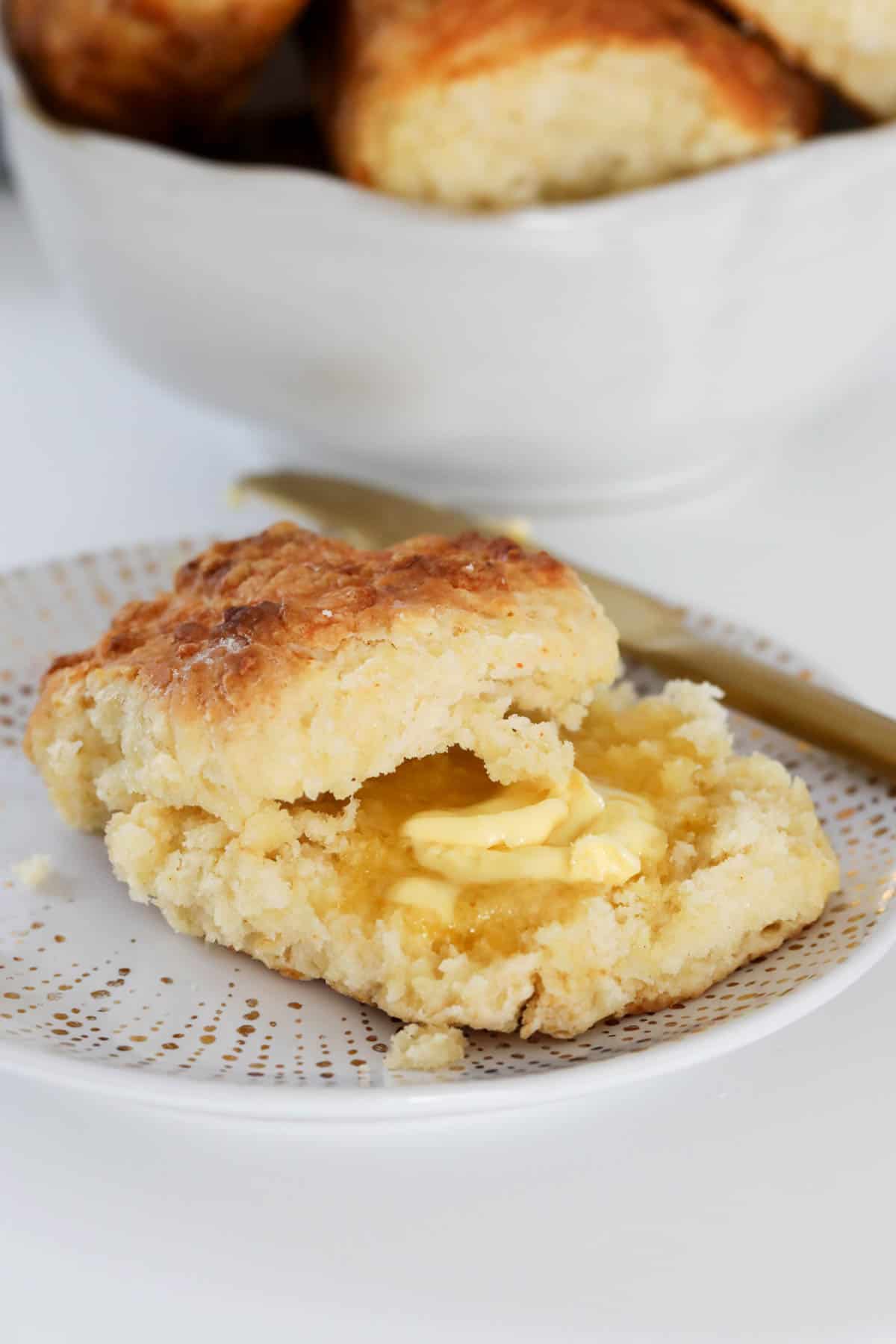 A buttered scone, cut and served on a plate.