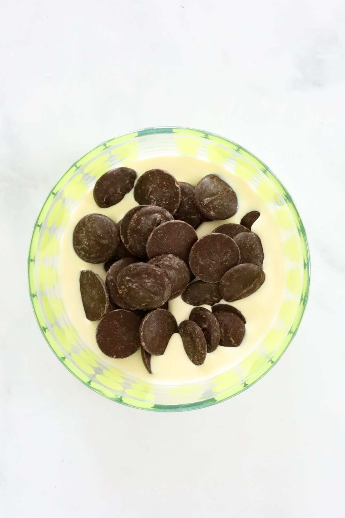 Chocolate melts and cream in a mixing bowl.