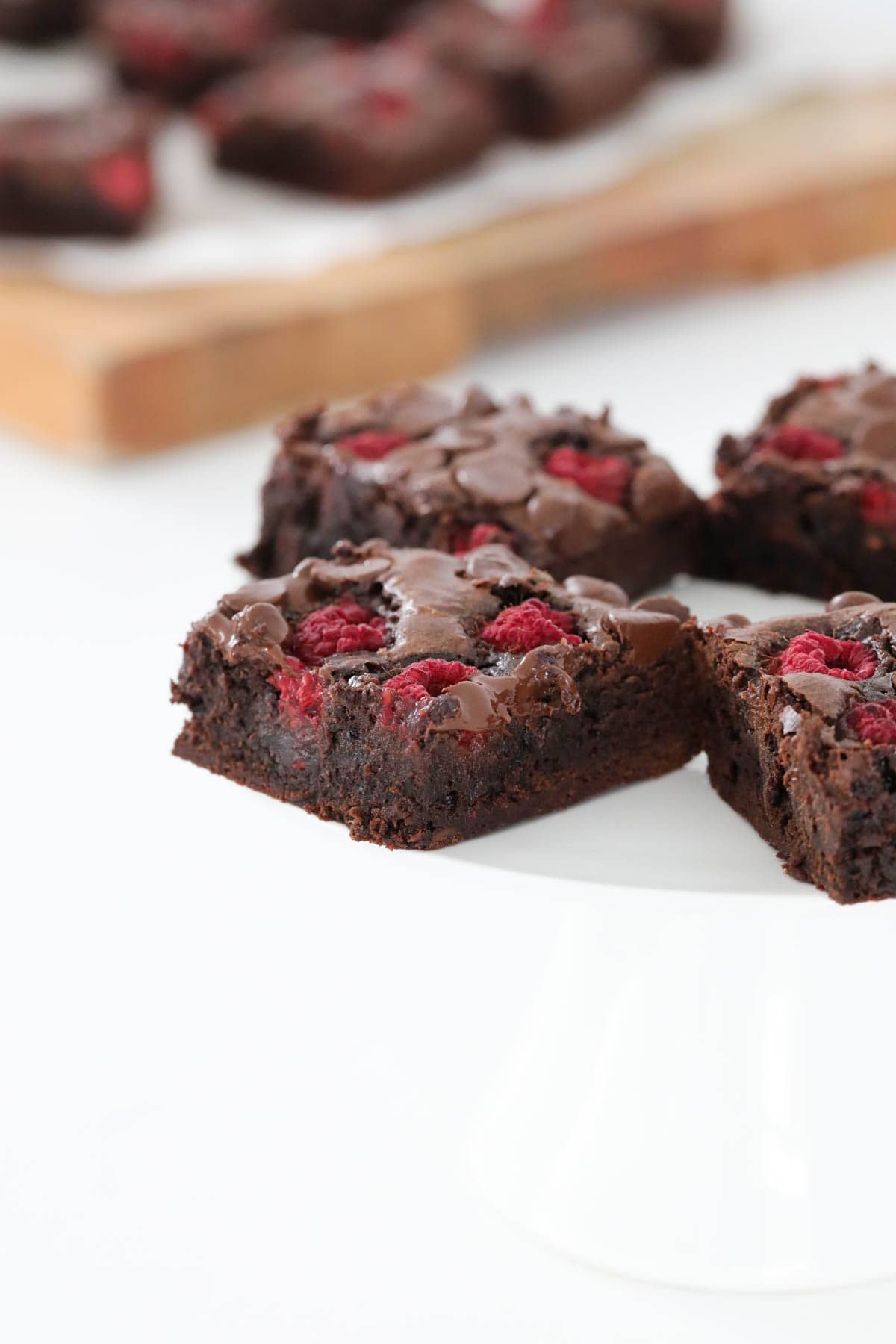 Raspberry brownie squares served on a plate.