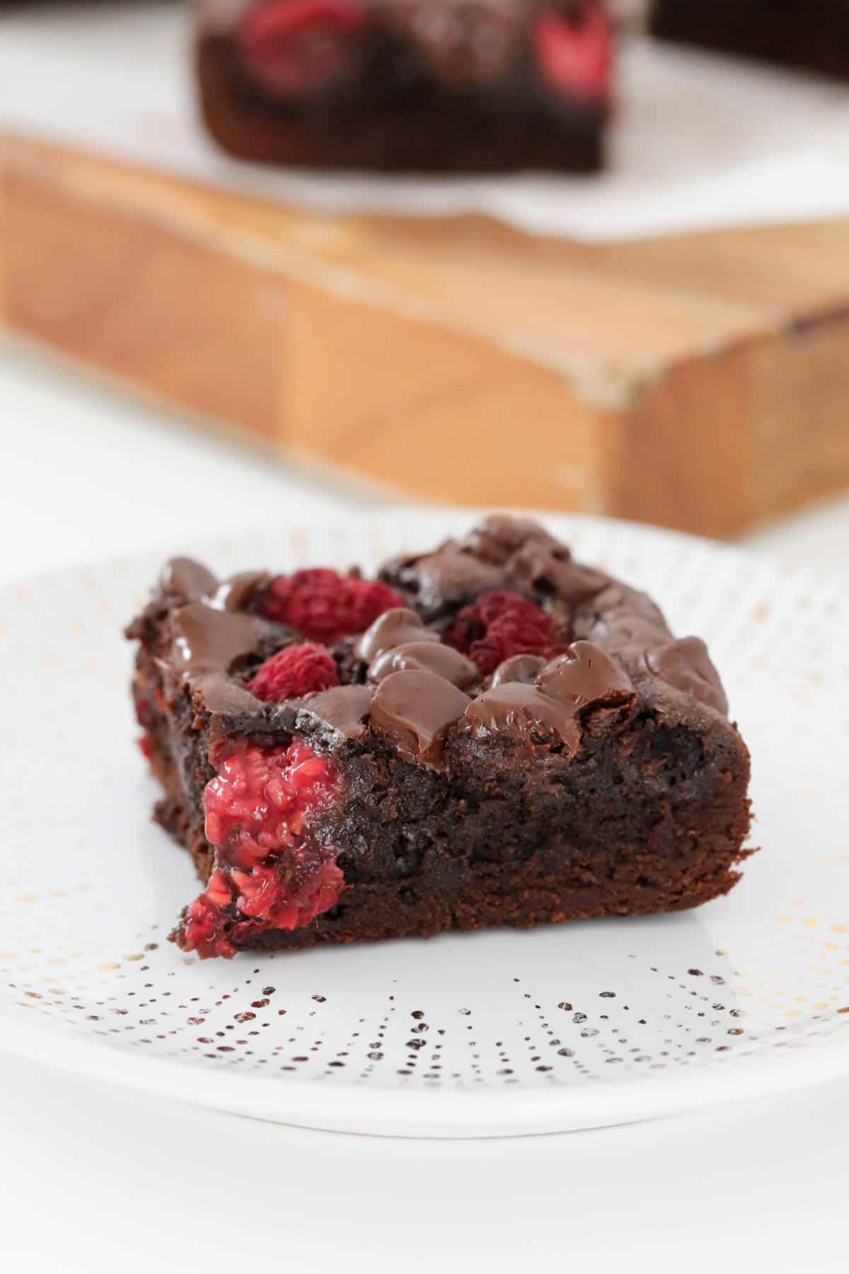 One piece of slice showing dark chocolate chips and fresh raspberries inside.
