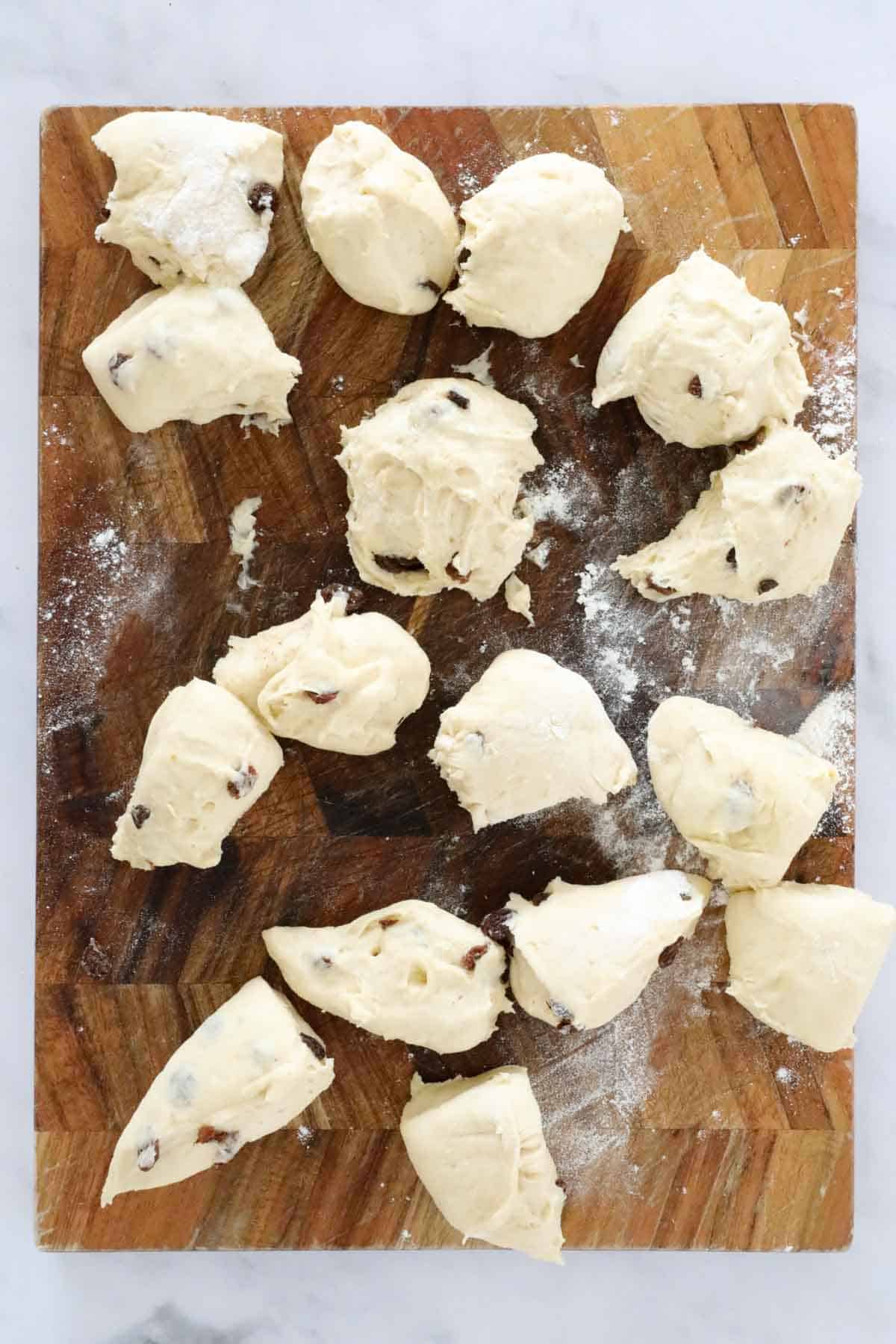 The dough cut in to pieces on a wooden board.