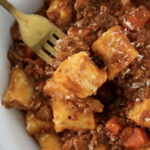 A bowl of homemade ricotta gnocchi with bolognese sauce.