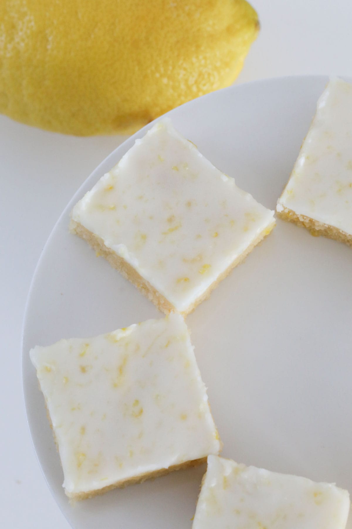 Overhead photo of lemon blondies on a white cake stand.