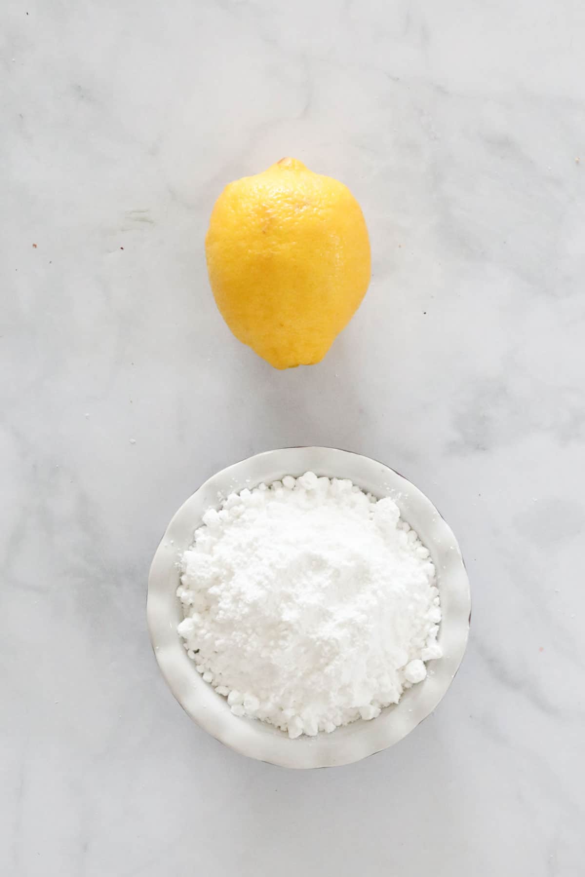 A fresh lemon and icing sugar needed to make the lemon icing to top the blondies with.