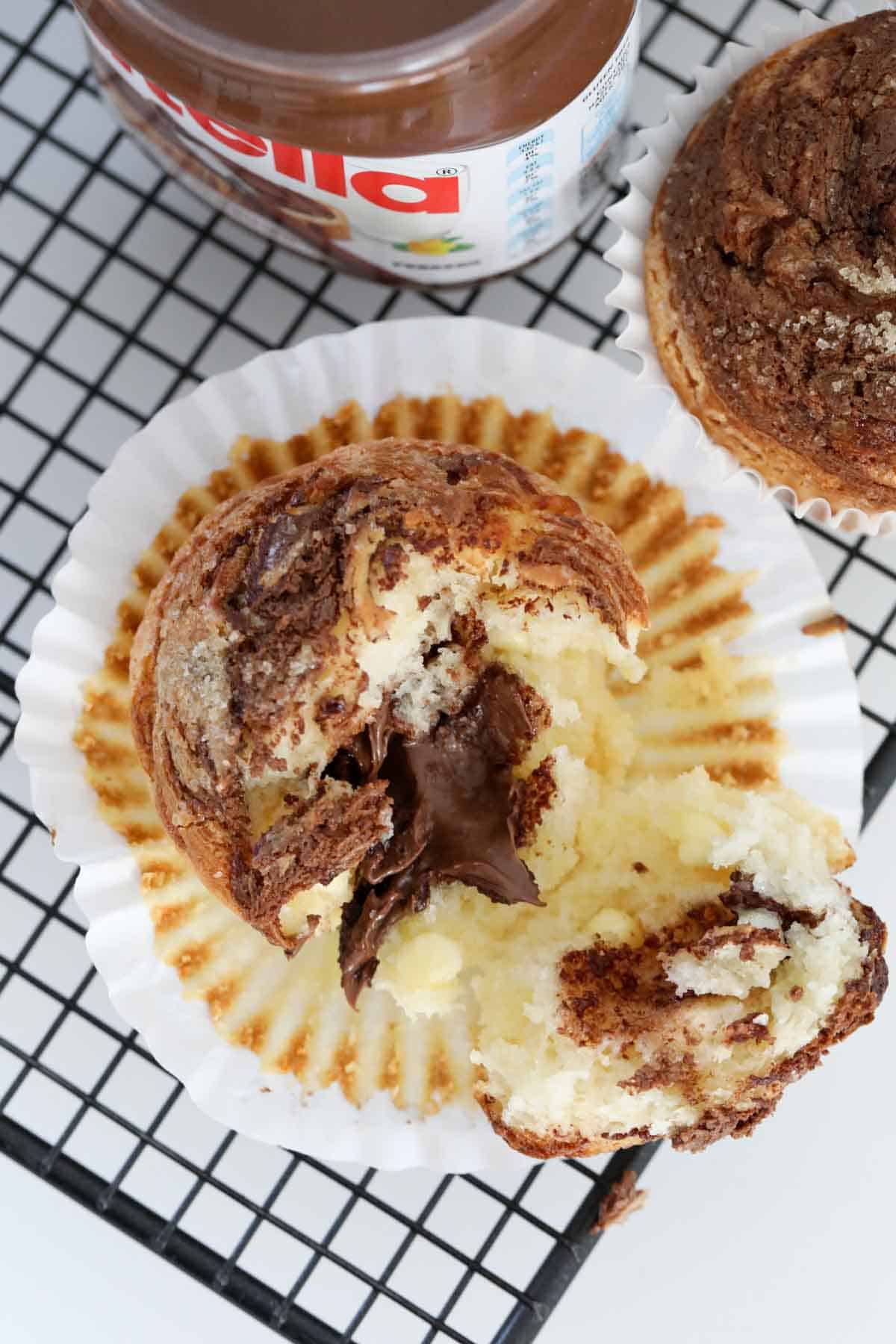 An overhead shot of Nutella oozing out of a muffin split in half.