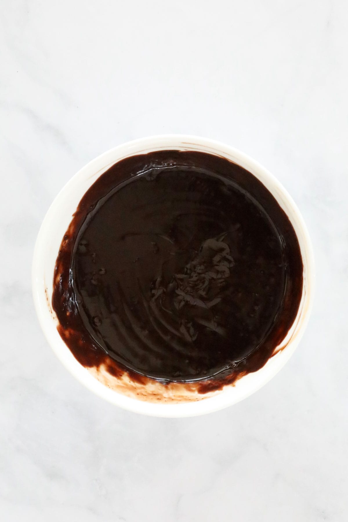 Stirred chocolate ganache in a bowl.