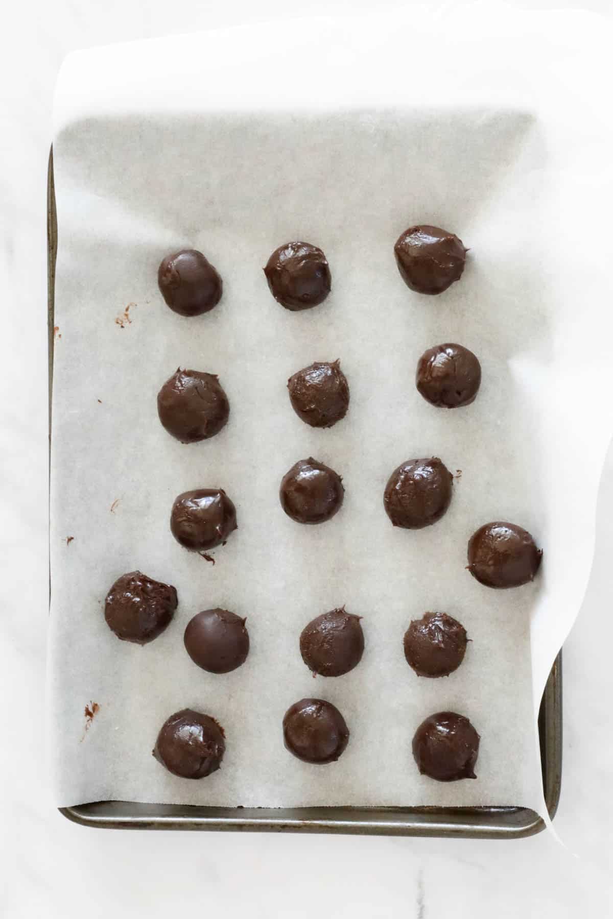 Teaspoons of the chocolate ganache rolled into balls and placed on baking paper.