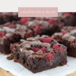 Squares of chocolate brownie, studded with fresh raspberries on top.