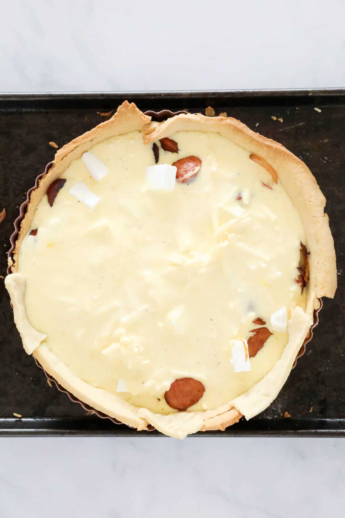 The cream and egg mixture poured over the fillings in the pasty case.