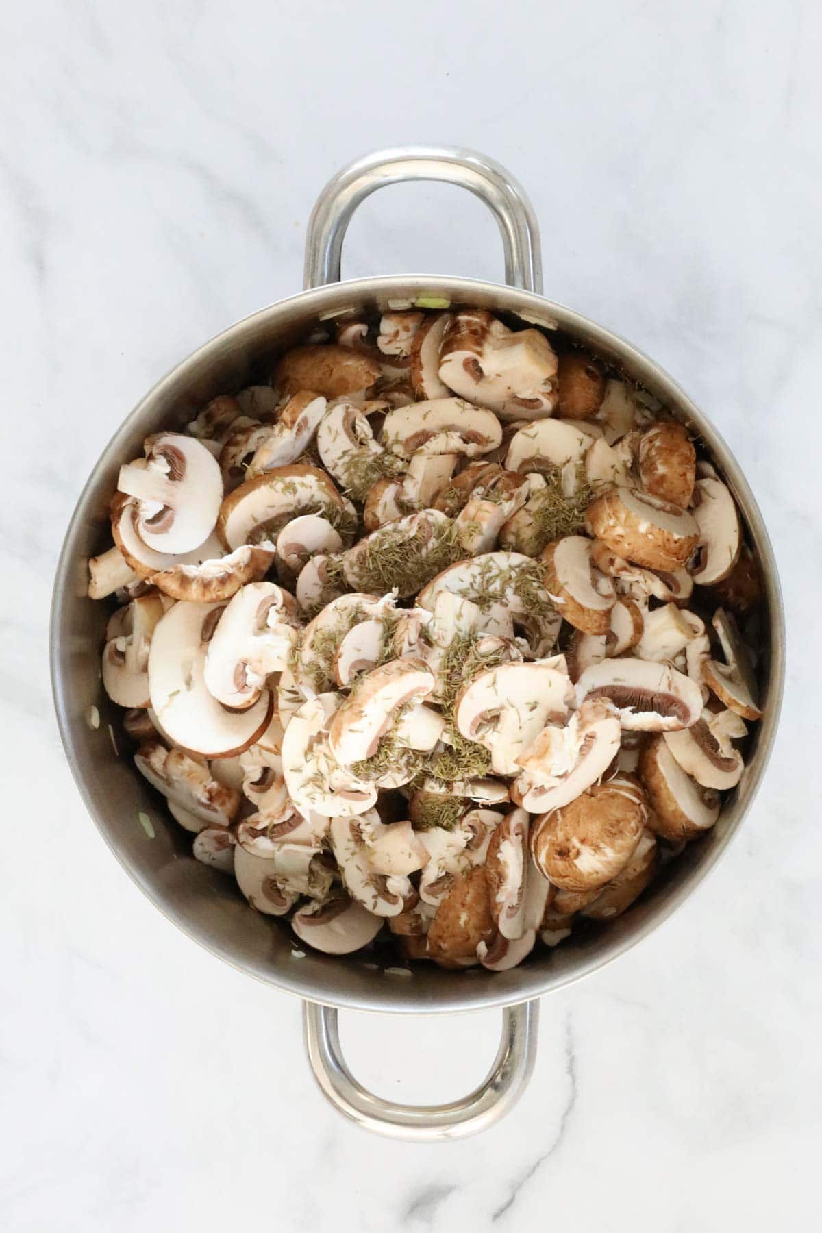 Sliced mushrooms and thyme added to the pan.