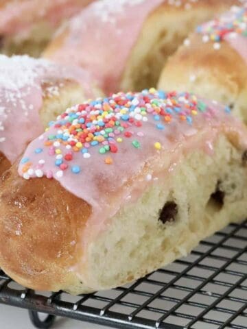 Soft finger buns with pink icing and sprinkles.