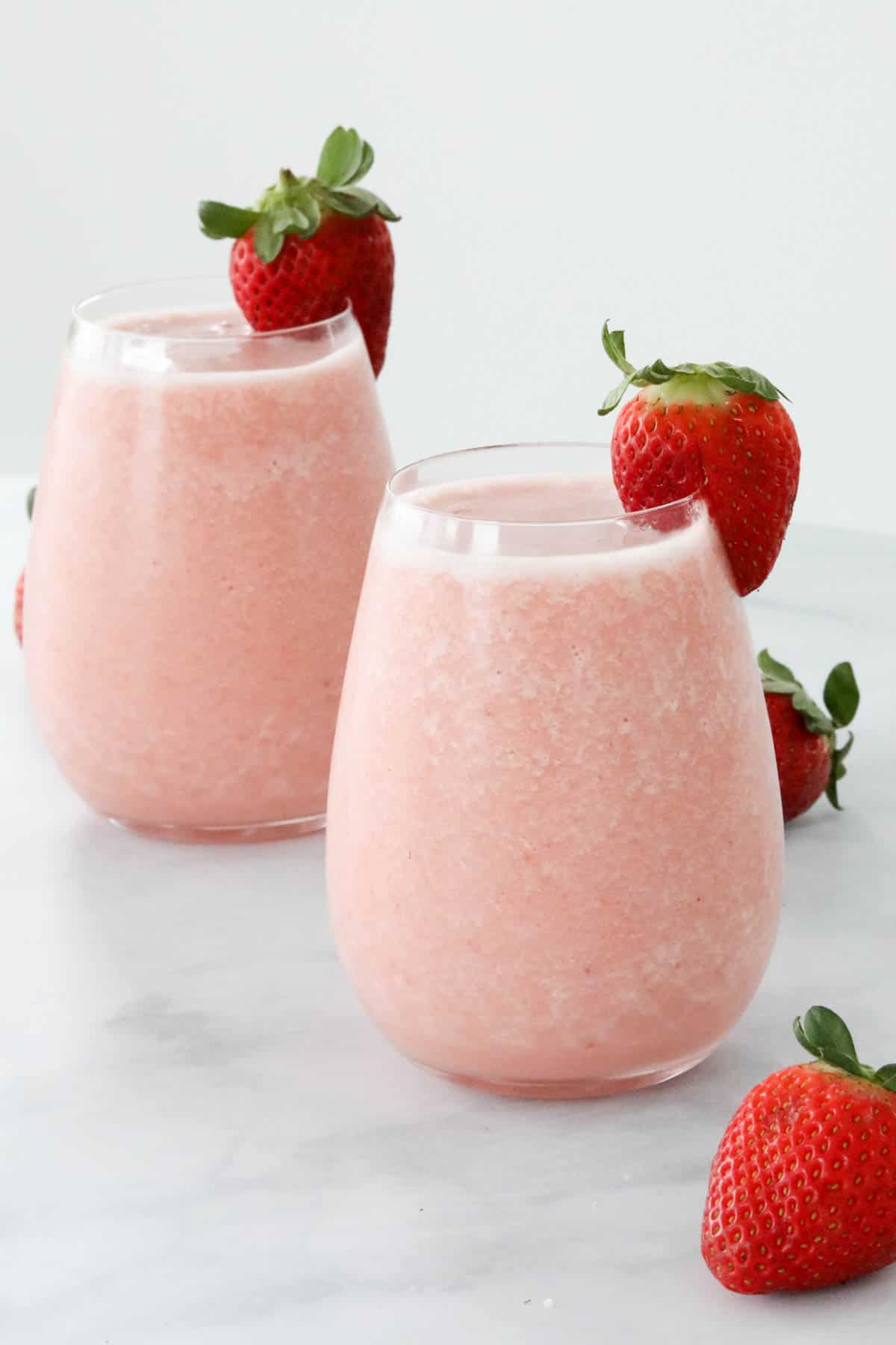 Two glasses filled with a strawberry colada.