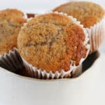 Sugar crusted banana muffins in white paper cases.