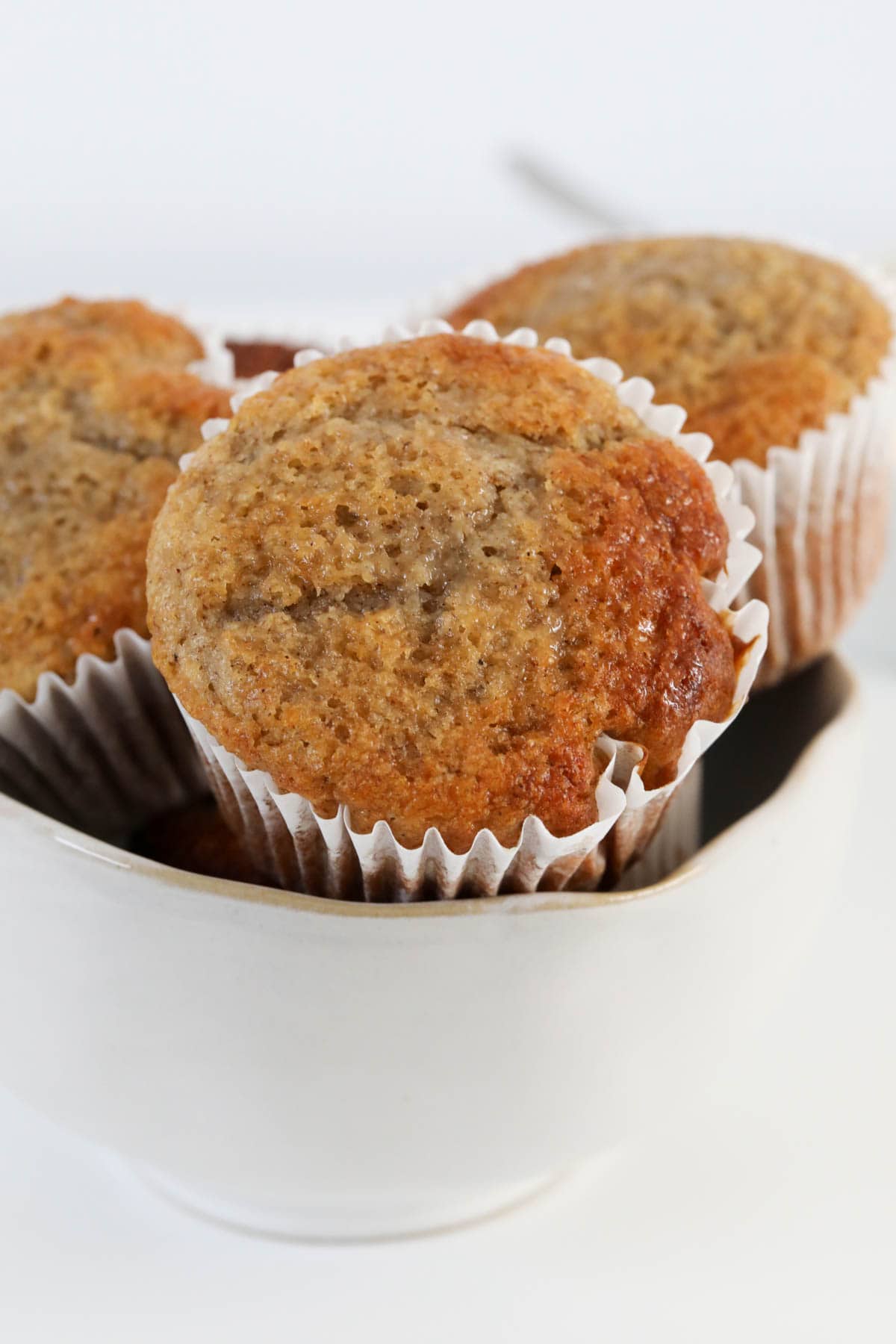 Sugar crusted banana muffins in white paper cases.