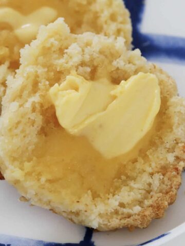 A gluten free cheese scone smothered with butter.