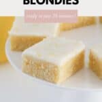 Tangy lemon blondies squares on a white cake stand.