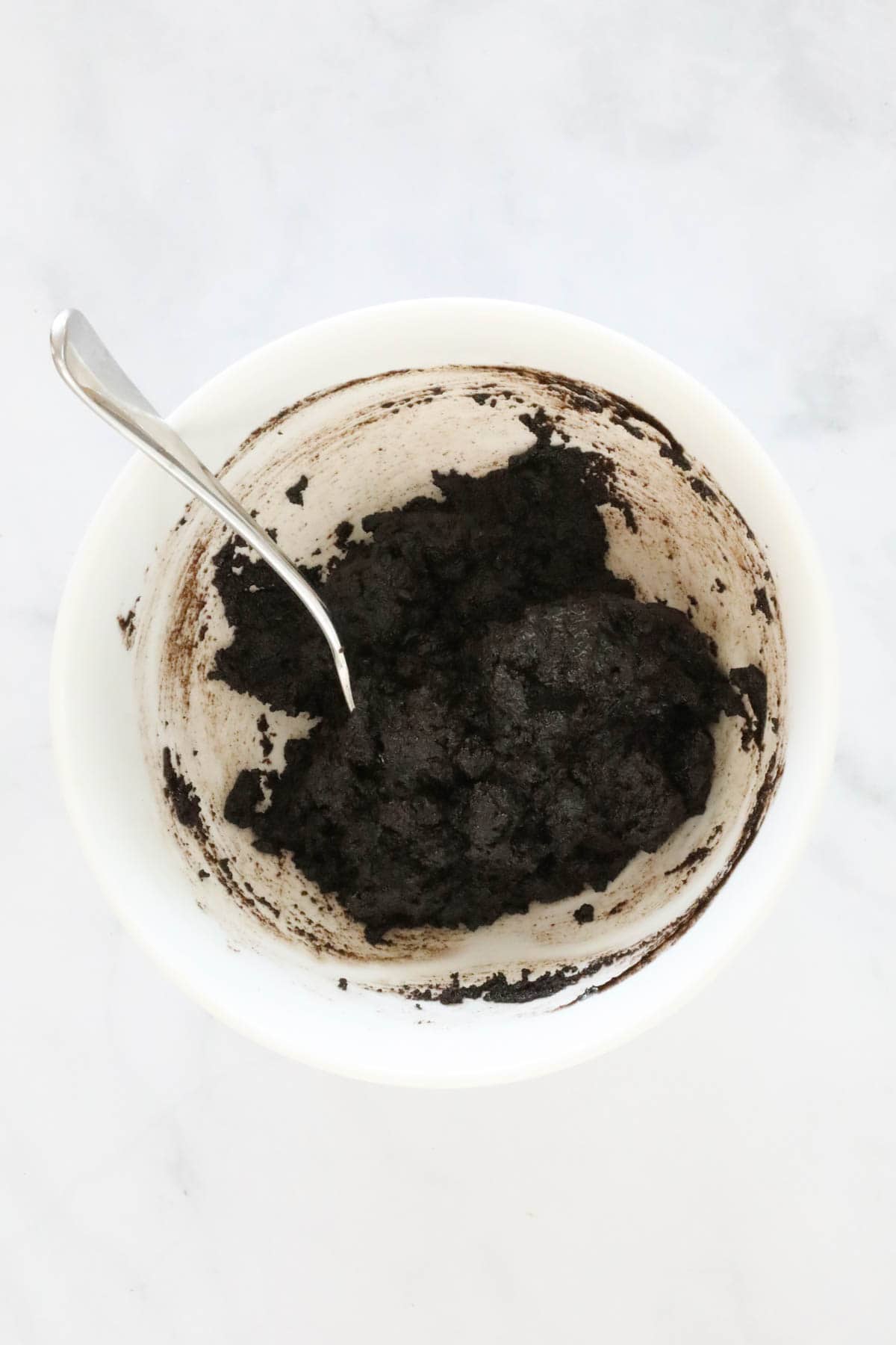 Melted butter mixed with crushed Oreo's in a mixing bowl.