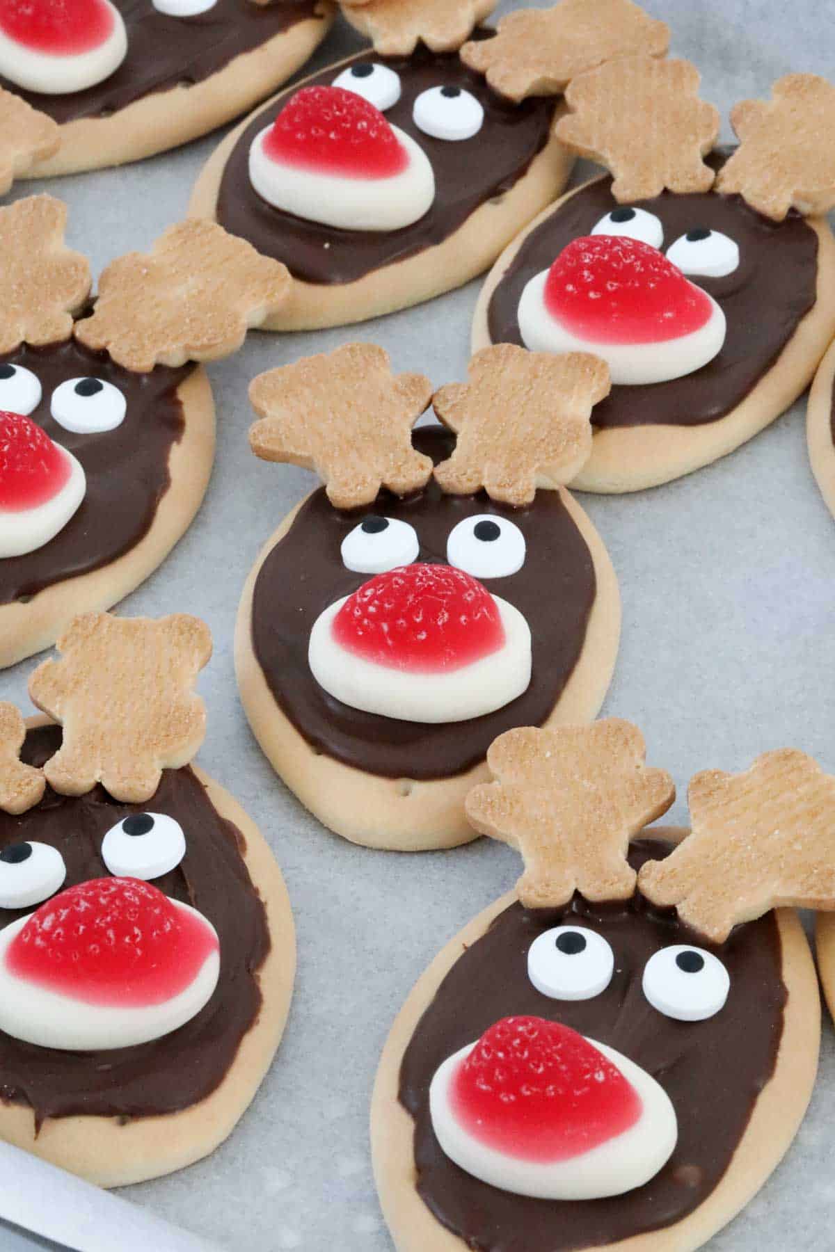 Angled view of cute reindeer biscuits on a lined tray.