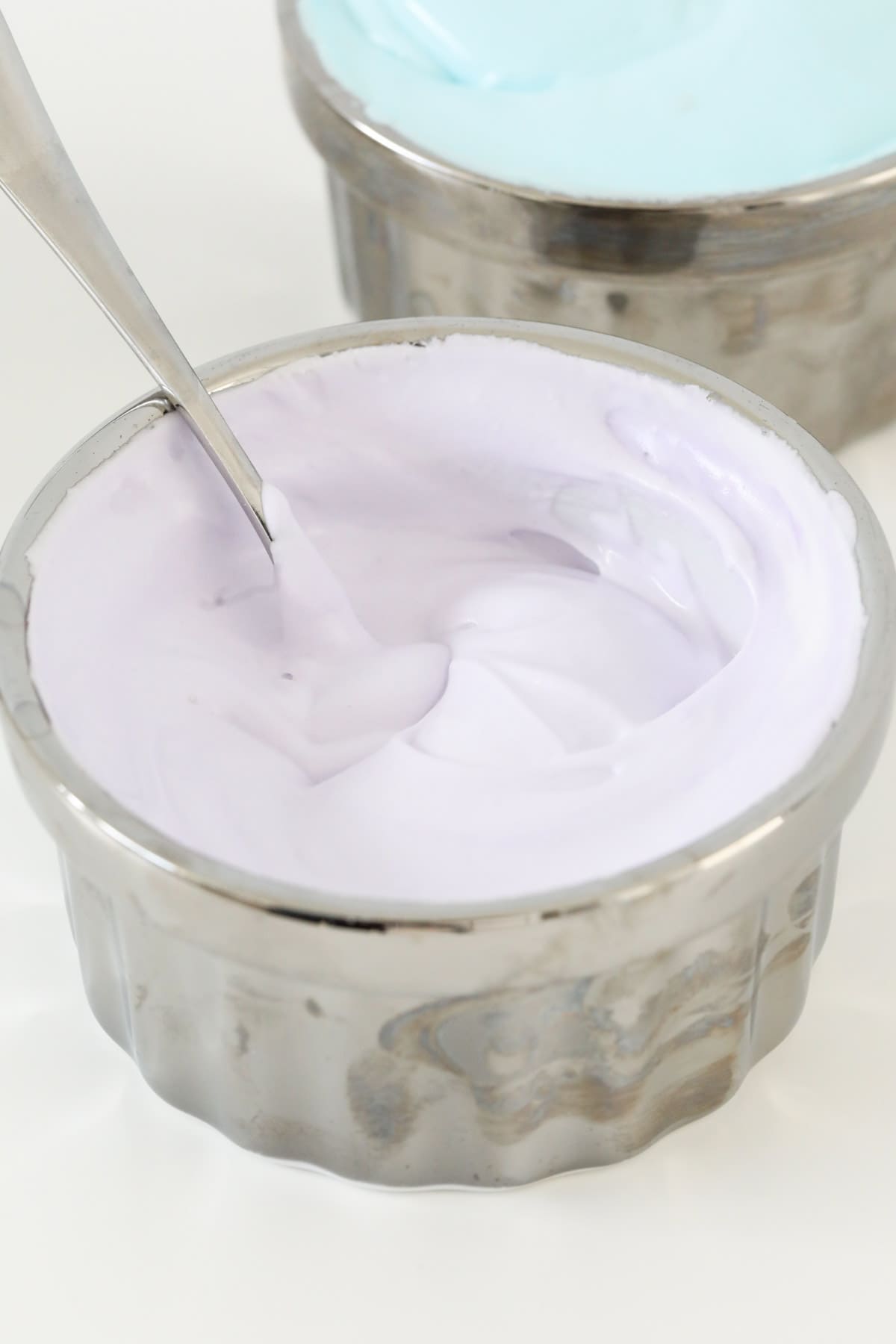 Side view of a bowl of purple royal icing.