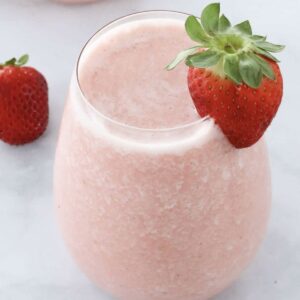 A creamy, fruity strawberry cocktail with a fresh strawberry on top.