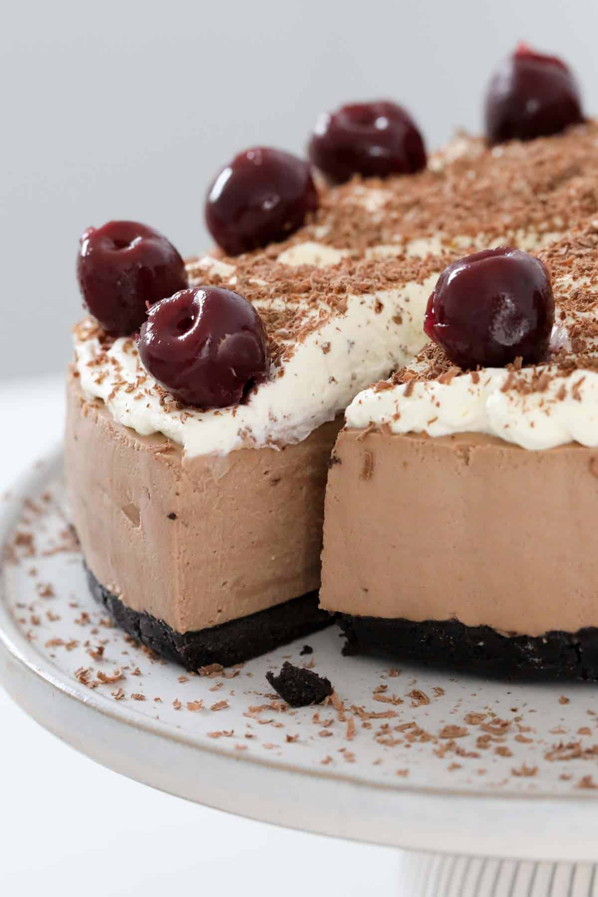 A Black Forest cjheesecake with one serve cut and slightly removed from the rest.