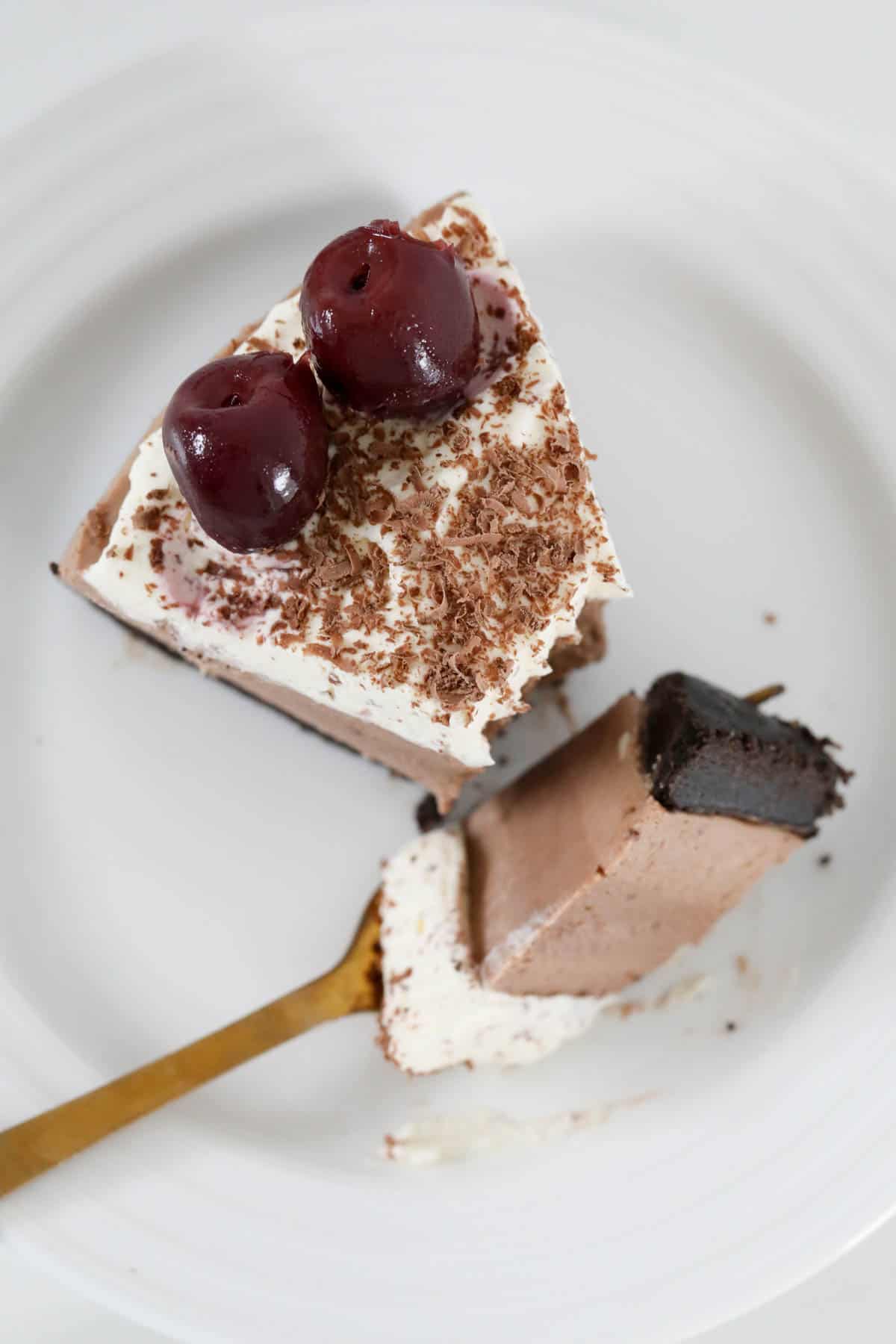 Overhead shot of a serve of black forest cheescake with some on a fork.