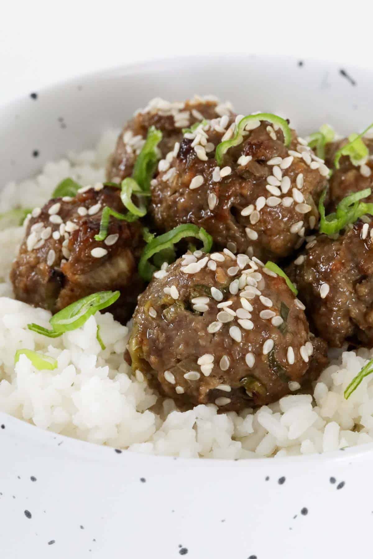 A bowl of Bulgogi meatballs served with rice and sprinkled with sesame seeds.