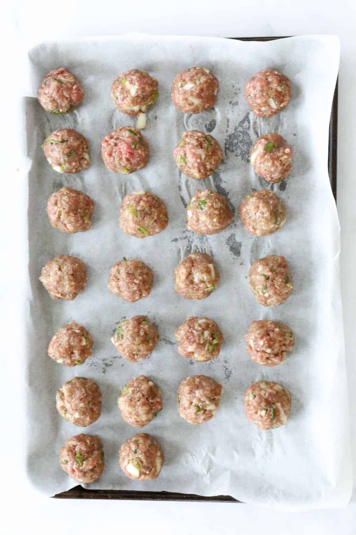 The rolled Bulgogi meatballs on a tray lined with baking paper.