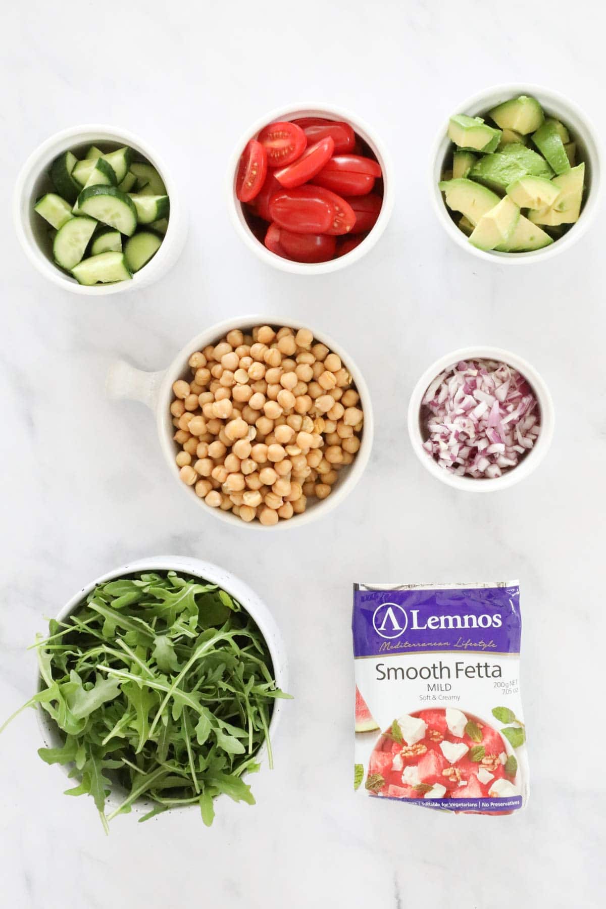 Ingredients needed for the chickpea salad measured out and placed in individual bowls.