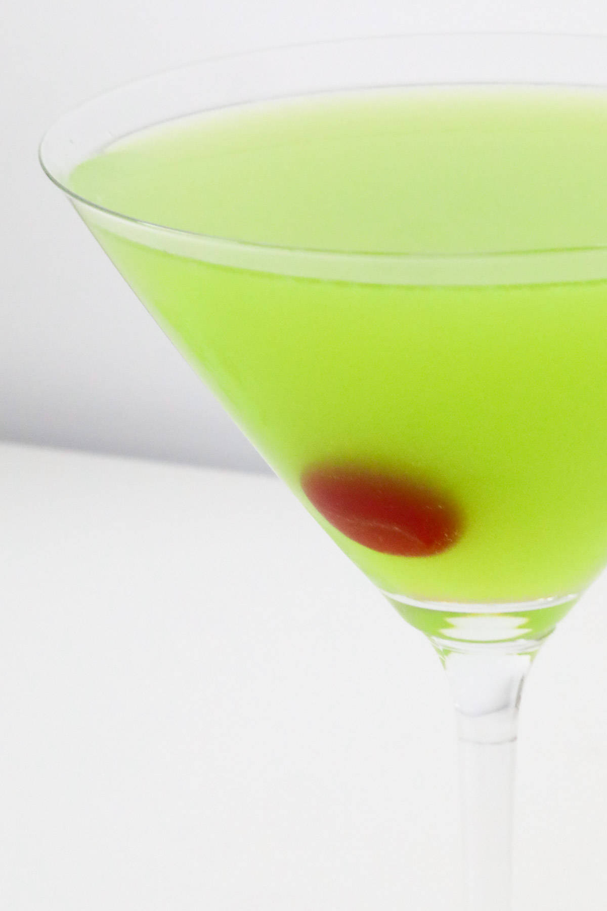 A Japanese Slipper pale green cocktail in a Martini glass, with a cherry in it.