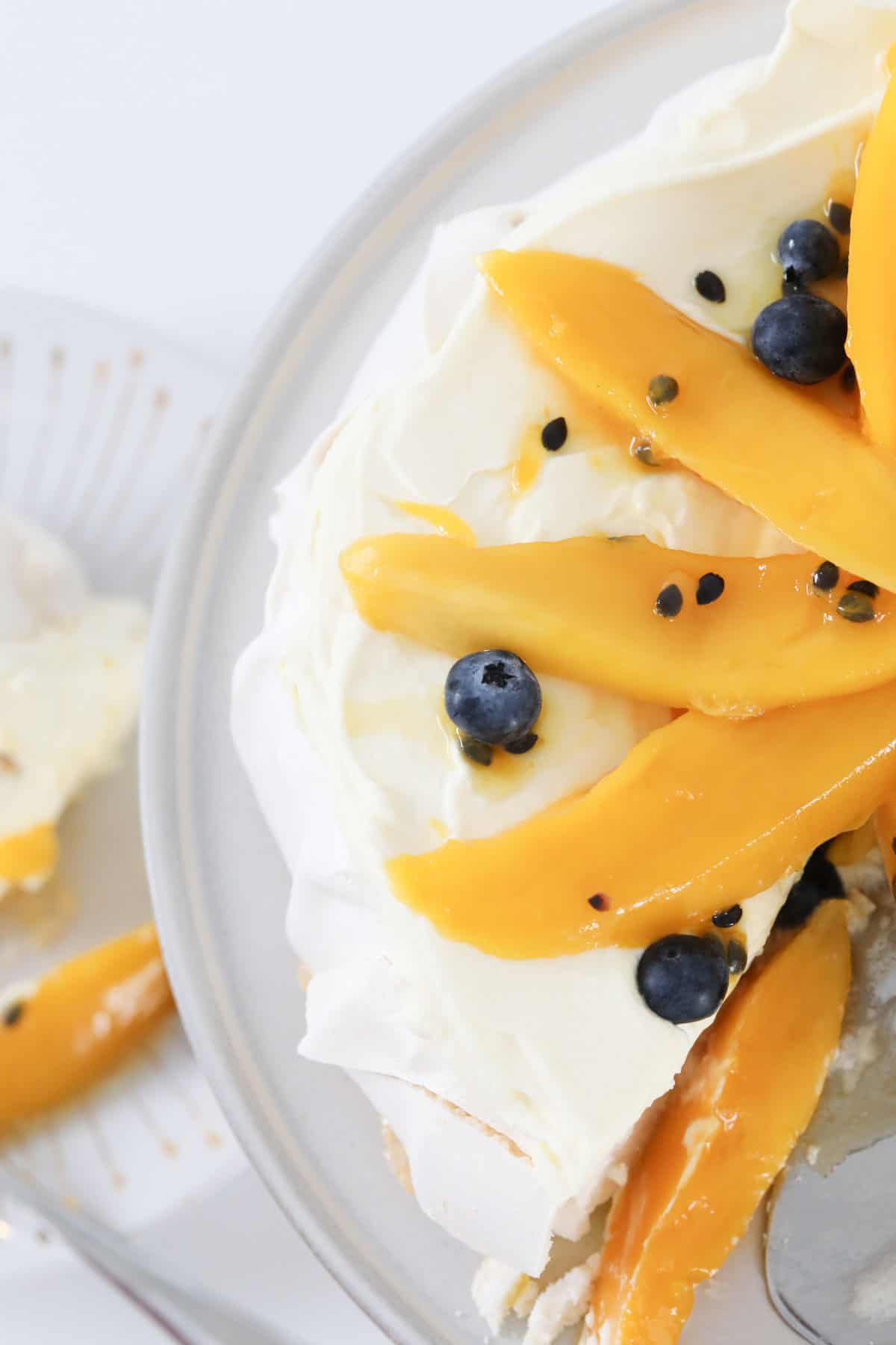 Top view of the pavlova decorated with mango and passionfruit.