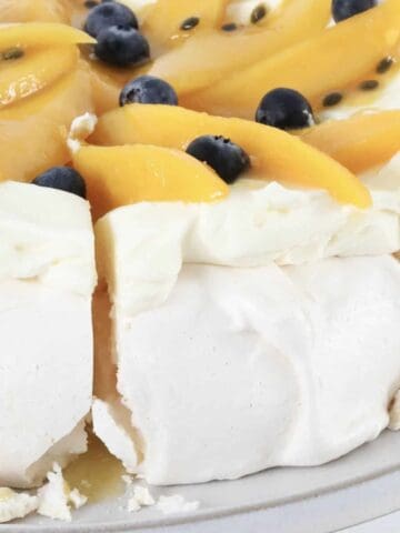 A slice of mango and passionfruit pavlova being removed.
