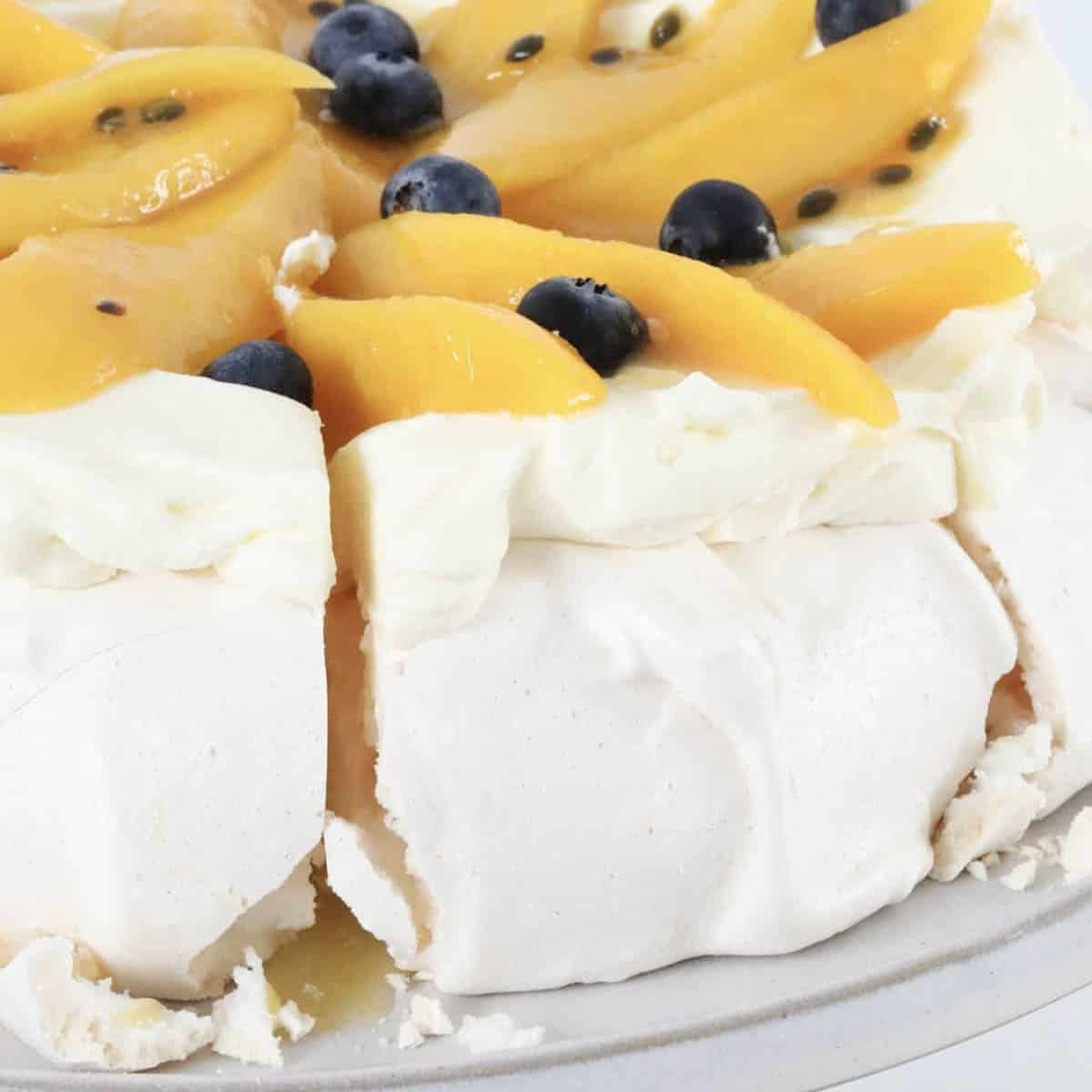 A slice of mango and passionfruit pavlova being removed.
