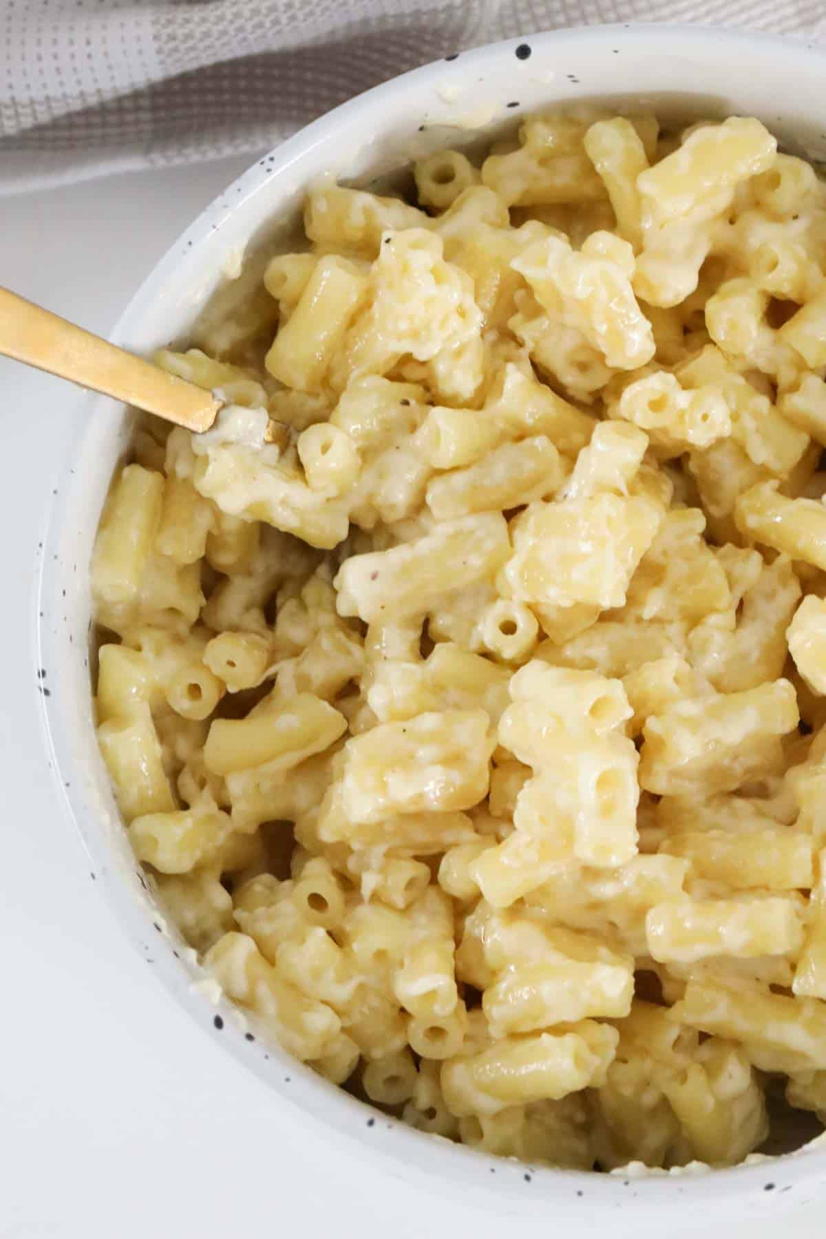 Macaroni coated in cheese sauce in a serving bowl.