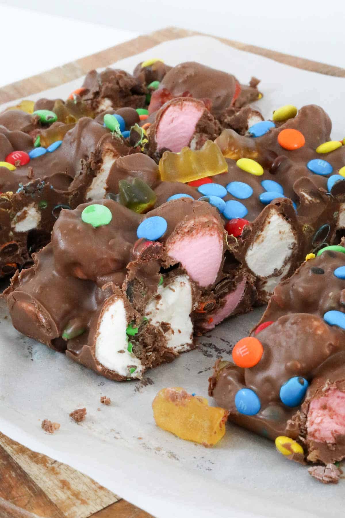 Close up of a large slice of rocky road to show the marshmallows and gummi bears.