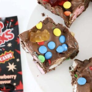 A piece of rocky road with mini M&Ms, gummi bears, marshmallows and popping candy.