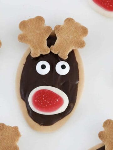 A reindeer made from an oval biscuit, melted chocolate, edible eyes, jelly mouth and tiny teddies.