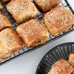 Crispy flakey sausage rolls on a wire rack.