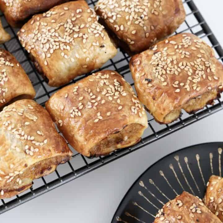 Crispy flakey sausage rolls on a wire rack.