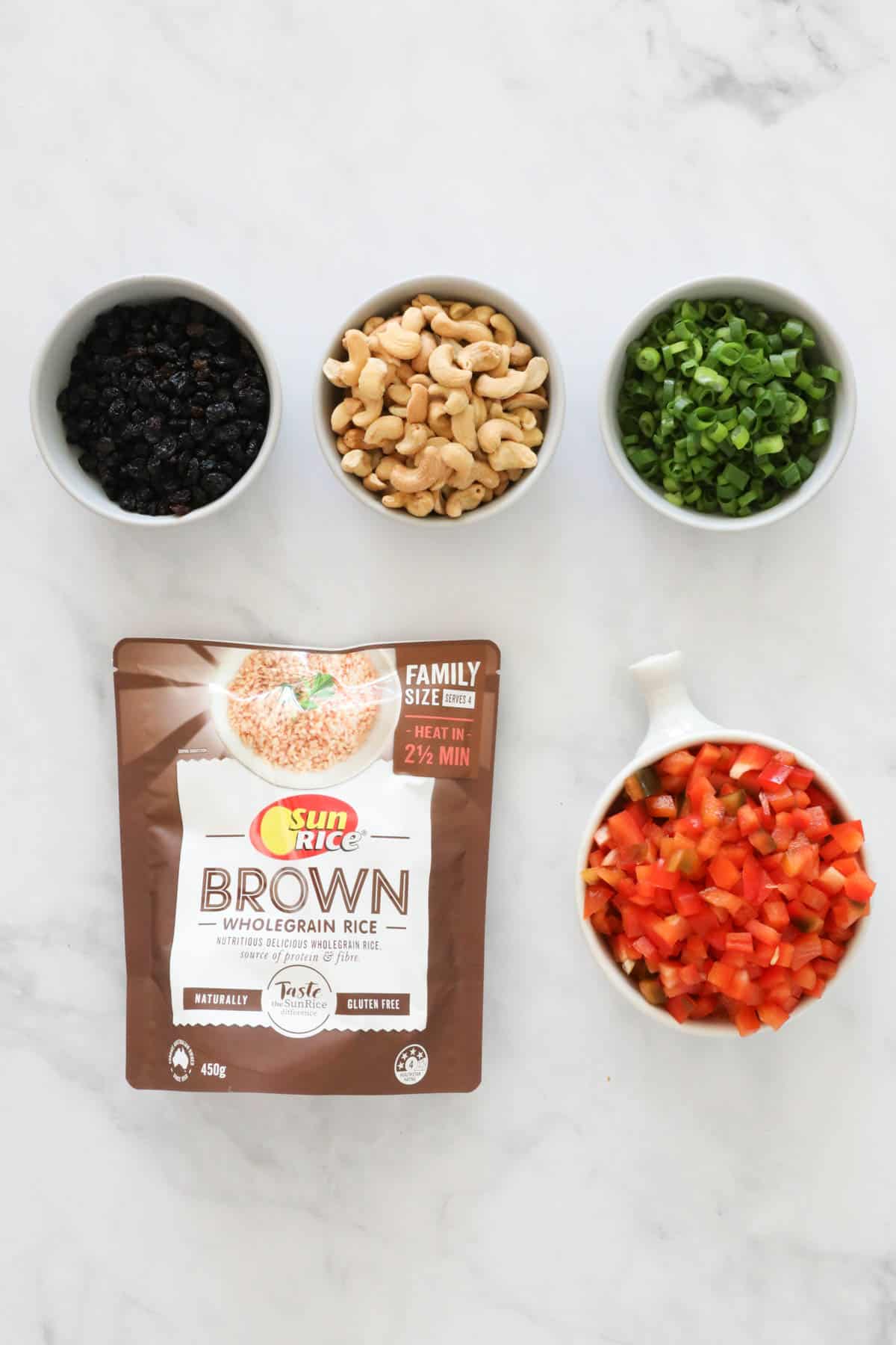 Ingredients needed to make the brown rice salad weighed out and placed in individual bowls.
