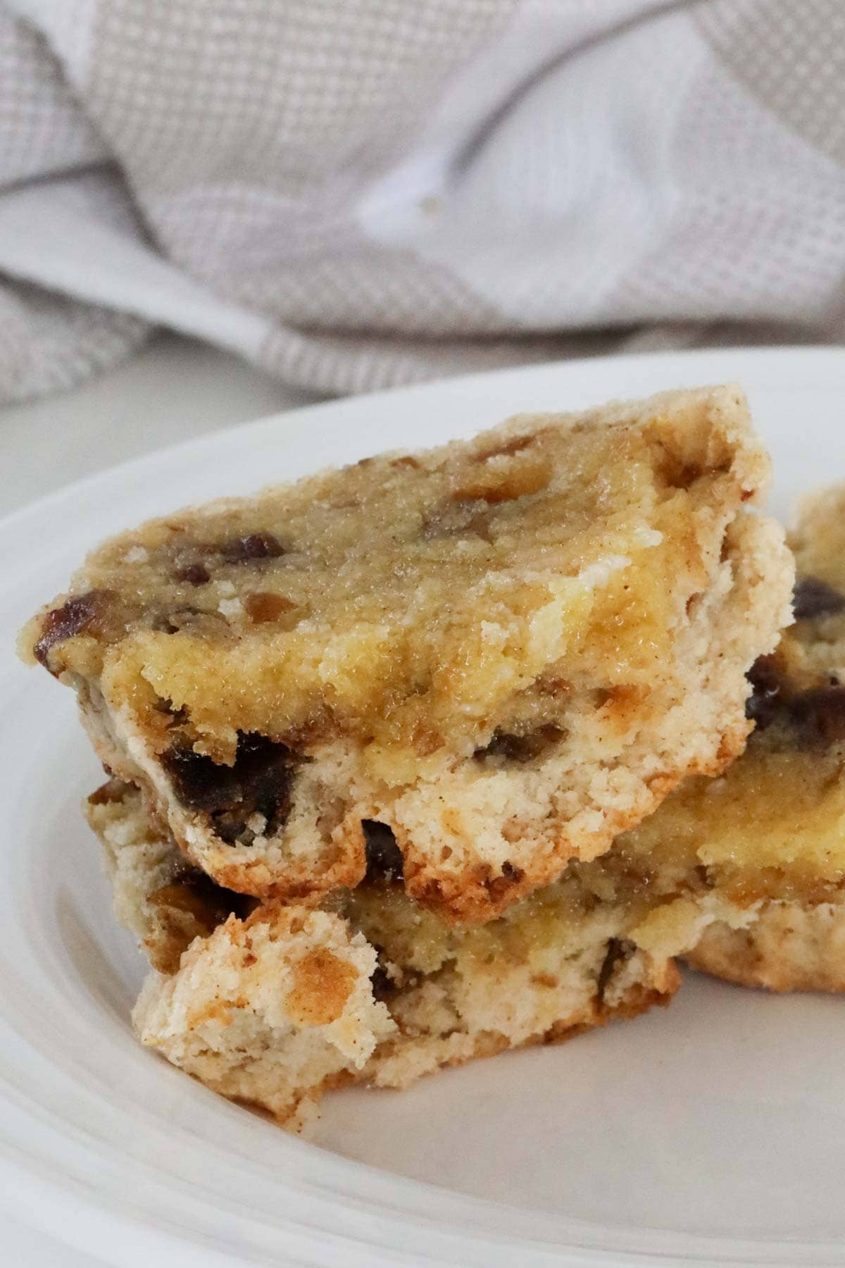 A cut and buttered date scone on a plate.