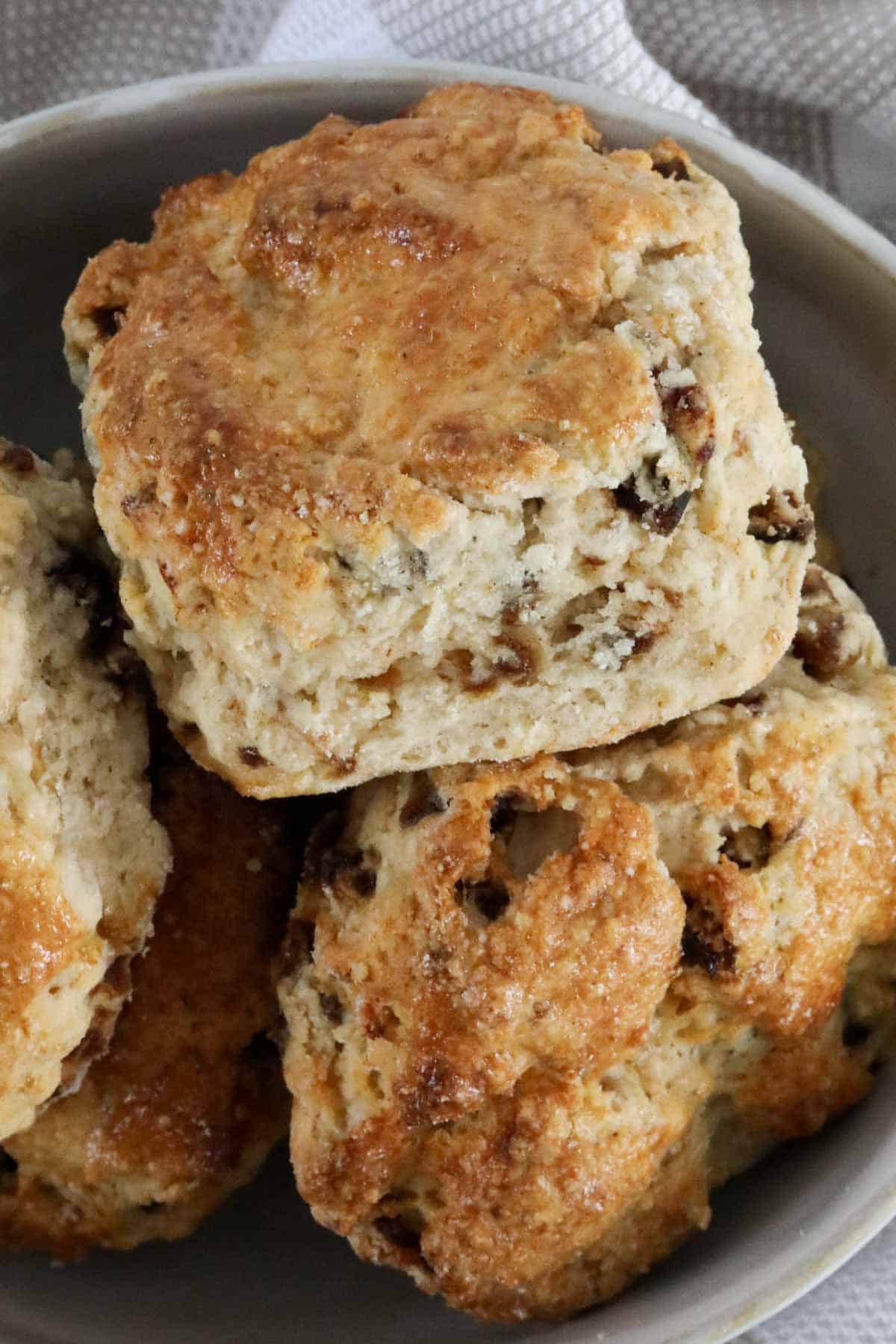 A close up of a batch of golden baked date scones.