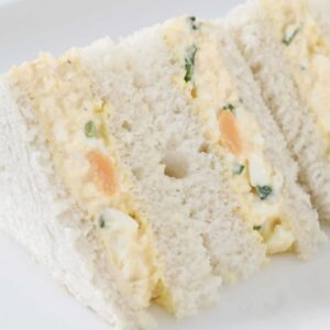 A plate of creamy egg sandwiches with mayonnaise.