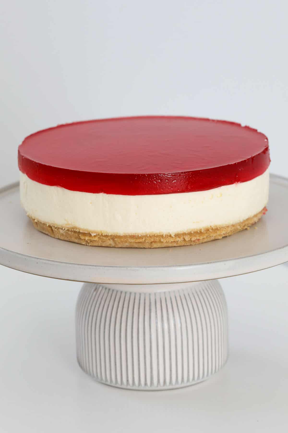 A chilled jelly cheesecake on a cake stand.