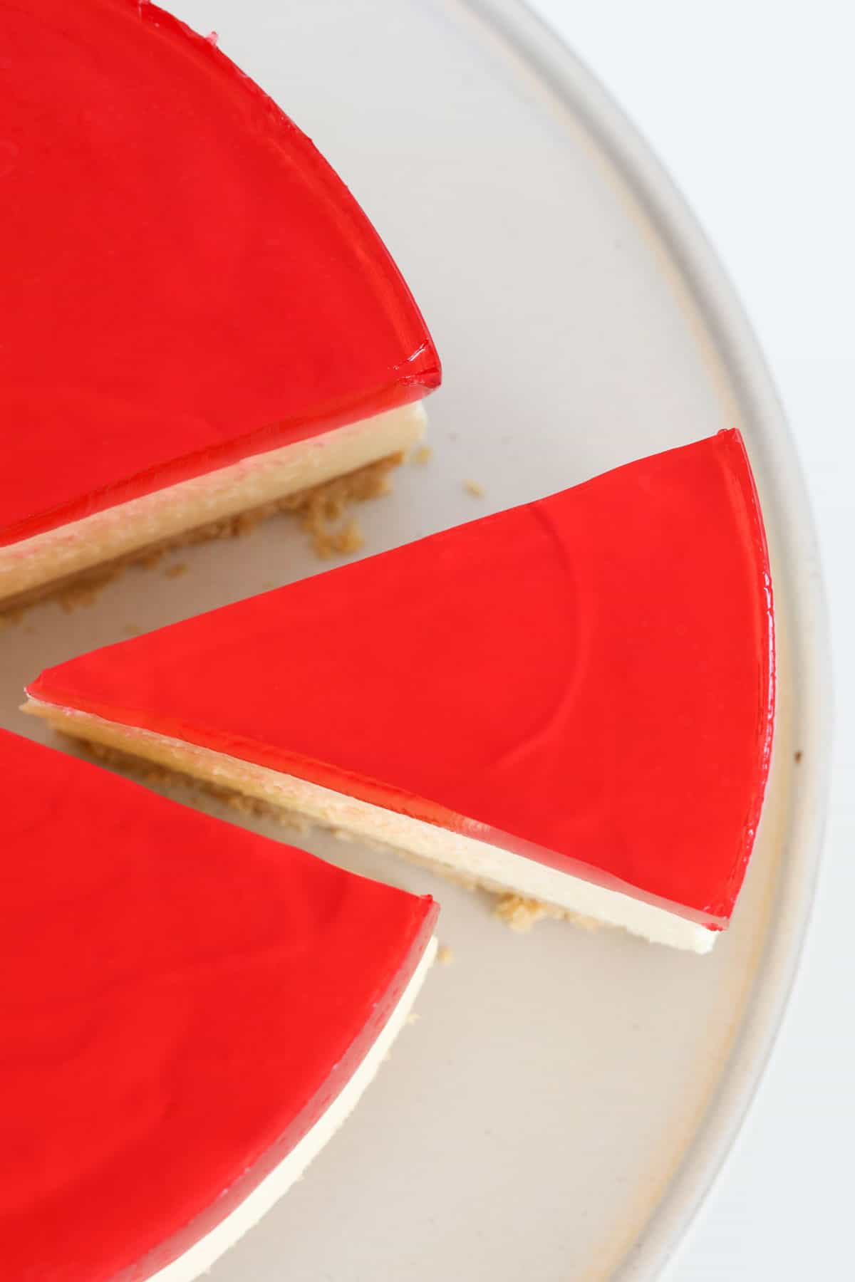 An overhead shot of a red jelly topped cheesecake.