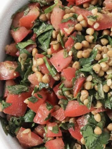 A bowl of tabouli made with lentils, parsley, tomatoes and mint.