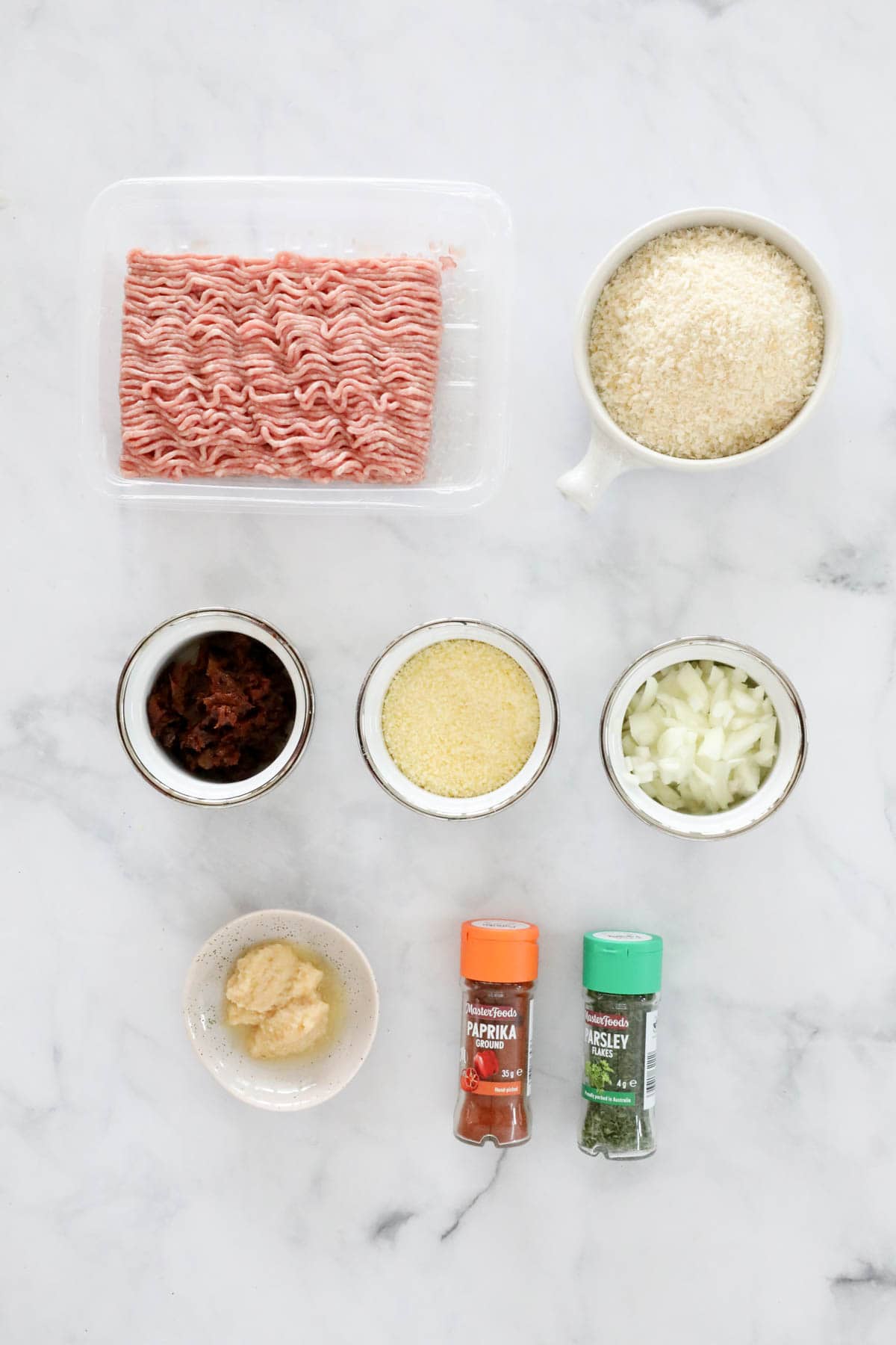 Ingredients needed to make the pork meatballs measured out in individual bowls.