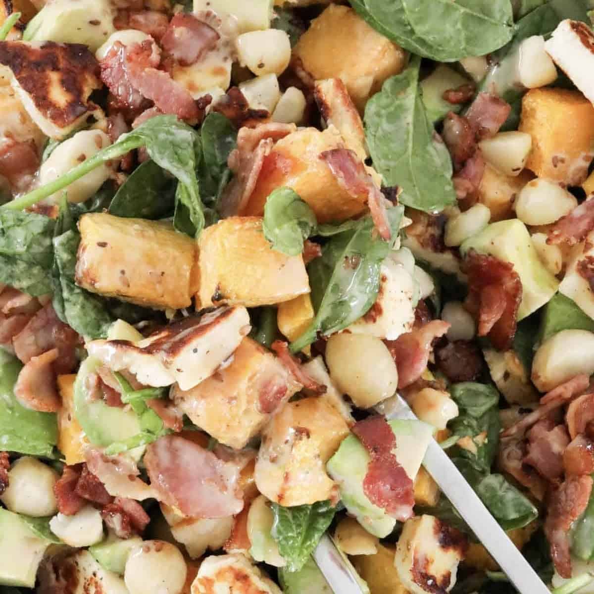 A halloumi salad with crispy bacon, macadamia nuts, avocado and sweet roast pumpkin tossed with a creamy sesame dressing.