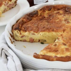 A baking dish filled with a cheesy, creamy bacon quiche.